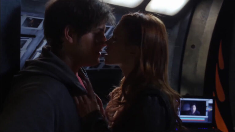 Ginn (Julie McNiven) and Eli (David Blue) kiss